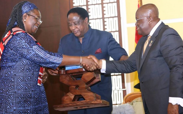 President Akufo-Addo presenting a gift to Me Clemence Some Troare, out-going Burkina Ambassador to Ghana. Looking on is Mr Ahmed Alhassan (middle), Director, State Protocol President Akufo-Addo presenting a gift to Me Clemence Some Troare, out-going Burkina Ambassador to Ghana. Looking on is Mr Ahmed Alhassan (middle), Director, State Protocol